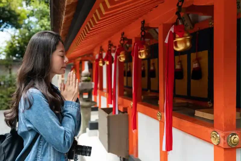 una donna sta pregando ad un tempio a kyoto giappone , i templi giapponesi